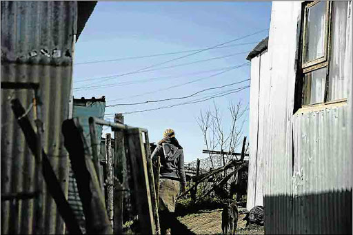 A resident and her pet in Residents and pets walk in Duncan Village, which has one of the highest numbers of illegal electricity connections in Buffalo City Metro Picture: FILE