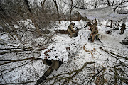 Ukrainian servicemen cover a M777 howitzer after firing toward Russian troops at a position near a front line, amid Russia's attack on Ukraine, in Zaporizhzhia region, Ukraine, on January 14 2024. 