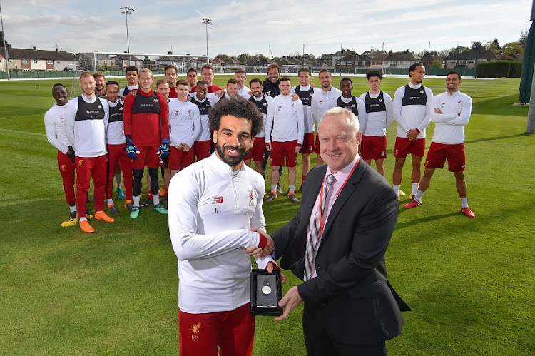 Mohamed Salah of Liverpool with Simon Barker Assistant Chief Executive of the PFA and his team mates and manager Jurgen Klopp after winning the PFA Team of the Year Award at Melwood Training Ground on April 30, 2018 in Liverpool, England.