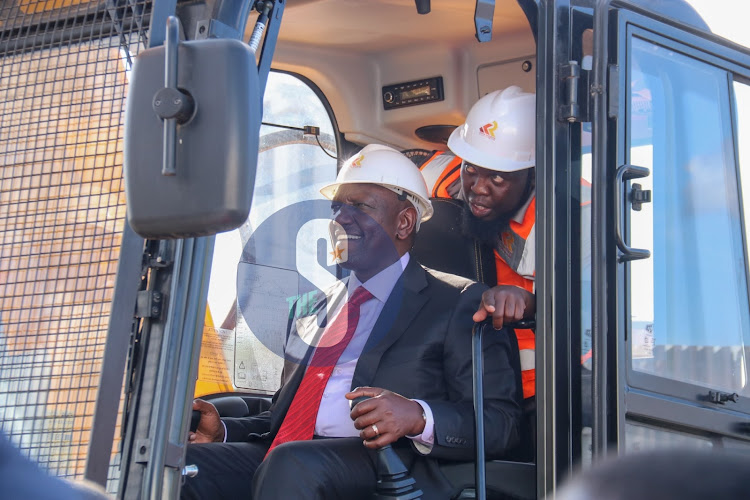 President William Ruto taken through the operations of an excavator during the launching of the construction of the Nairobi Railways City at Nairobi Railways station on December 7, 2022.