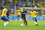 ON THE RUN: Thabiso Kutumela of  Orlando Pirates and Oupa Manyisa of  Mamelodi Sundowns scramble for possession during the Absa Premiership match between  the two teams at Orlando Stadium on Wednesday night. Sundowns won 3-1.