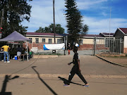 An Imbali resident walks past the voting station in the crime-ridden township on Monday.