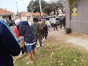 Durban residents queue at a spaza shop for basic supplies.