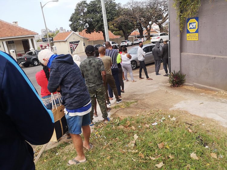 Durban residents queue at a spaza shop for basic supplies.