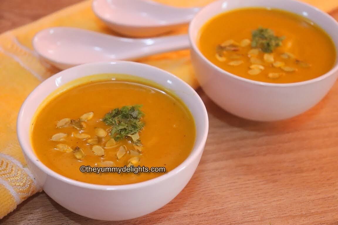 vegan pumpkin soup served in a white bowl. Garnished with toasted pumpkin seeds