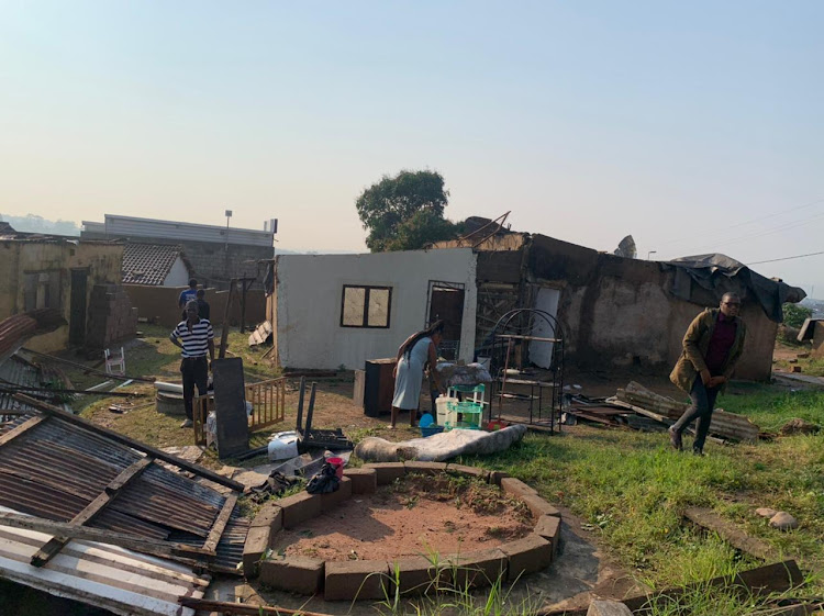 Ntombikhona Chirwa gets help to repar her home after heavy rains and a tornado hit Inanda, north of Durban