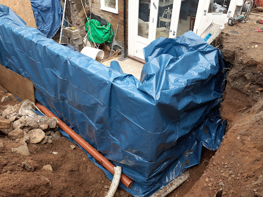 Porous pipe installed behind wall to cope with groundwater