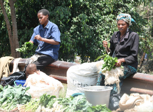 Women display sukuma wiki along a street in Kangemi.