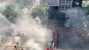 Demonstrators clash with police amidst a cloud of smoke during a protest in Yangon, Myanmar, March 4, 2021. 