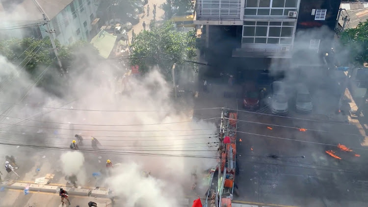 Demonstrators clash with police amidst a cloud of smoke during a protest in Yangon, Myanmar, March 4, 2021.