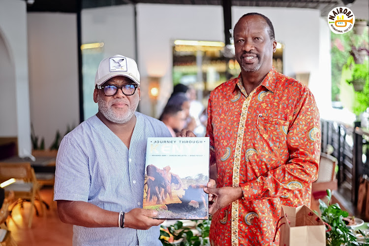 South African musician Jonathan Butler holds a book guide before his performance at the Nairobi International Festival on October 28, 2023./