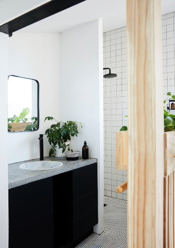 A half-height section of wooden panelling, topped with built-in planters and including a long towel rail on the bathroom side, separates the Hitchcocks’ bedroom from the shower, basin and vanity sections of the main bathroom. There’s plenty of under-counter storage in the custom vanity unit, which also includes a basin by WOMAG (womag.co.za) and tapware by Gio Plumbing (gioplumbing.com), who also made the shower rose.