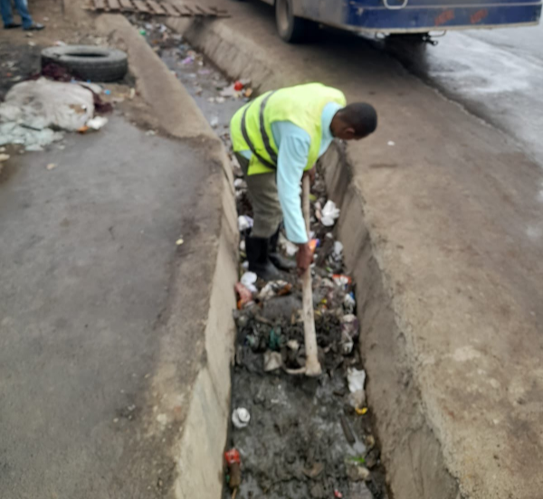 County worker unclogging a drainage terrace in Nairobi.