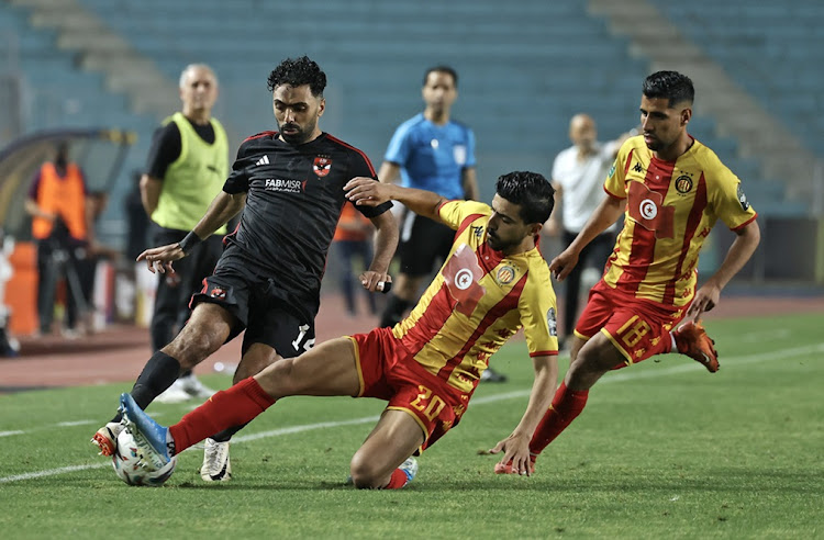 Hussein Elshahat of Al Ahly is challenged by Mohamed Ben Hamida of Esperance Tunis in the Caf Champions League final first leg match at Stade Hammadi Agrebi Stadium in Rades, Tunisia on Saturday night.