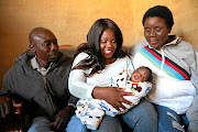 Sibongile Morudu holds  Precious, whom she helped deliver  a week ago, as parents  Thomas Rakhavha and Elina Maseko look on. 