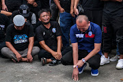 Players and officials of Arema FC mourn as they pay condolence to the victims outside Kanjuruhan Stadium in Malang, Indonesia on October 3 2022. A riot and stampede broke out at a football stadium in East Java on Saturday. Police fired tear gas to disperse fans who had invaded the pitch and began fighting after the match ended. A stampede for the exits has resulted in at least 125 deaths, local media reports said, with many still injured in hospitals.