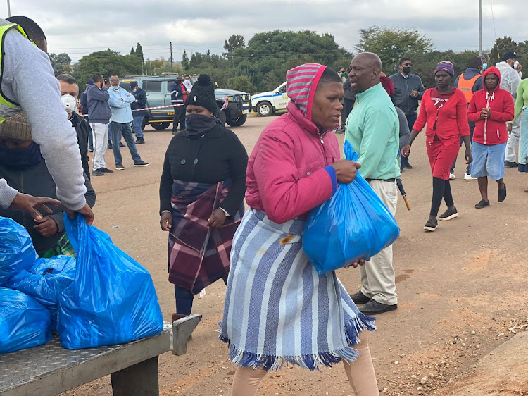 Residents of Mooiplaas informal settlement outside Centurion collect food hampers on Wednesday.