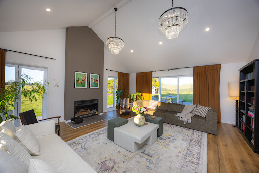Grand salon moderne avec cheminée et vue extérieure dans cette Maison de luxe à vendre à Palmerston North
