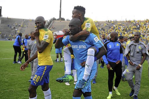 Pitso Mosimane celebrates the title win with his players after beating Ajax Cape Town .