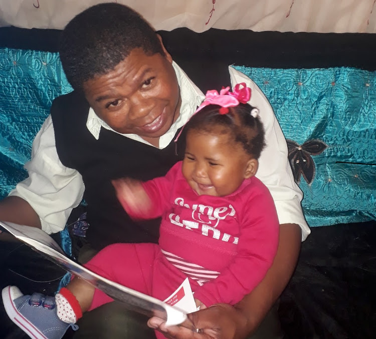 Dad Victor Arries reads to daughter Tiana, who has become the youngest reader at George municipality's Conville Library.