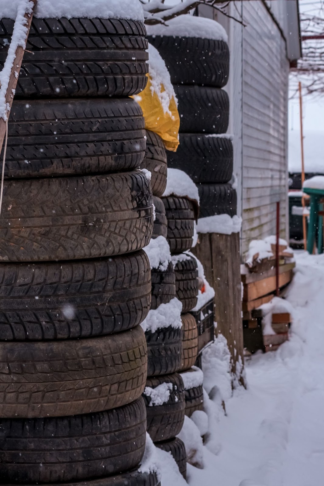 A stack of tires outdoors with snow on top of them