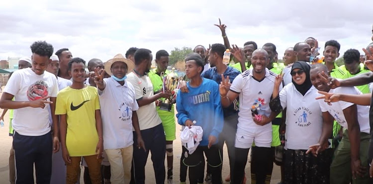 Players are joined by activists and residents after a football match that was meant to educate the community on the need to maintain peace on Tuesday, July 26.