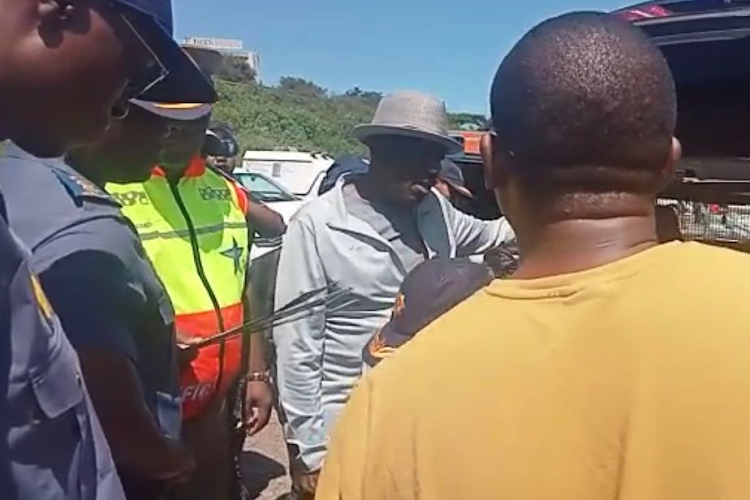 Police minister Bheki Cele asks the driver of a BMW X5 at a security check point why he has so many number plates