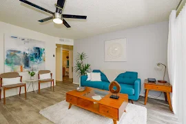 Two Bed, Two Bath model living room with blue couch and wood-inspired flooring