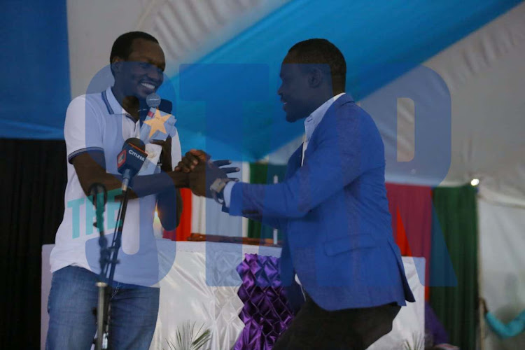 Dagoretti North MP Simba Arati shaking hands with his South Mugirango counterpart Silvanus Osoro during the burial of Bonchari MP Oroo Oyioka.