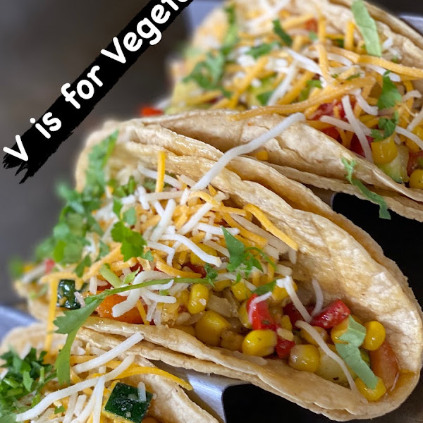 Pictured: Vegetarian Tacos with cheese and pico de gallo on corn tortillas