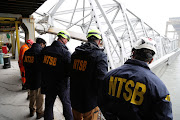 National Transportation Safety Board (NTSB) investigators work on the cargo vessel Dali, which struck and collapsed the Francis Scott Key Bridge, in Baltimore, Maryland, U.S. March 27, 2024. 