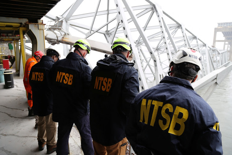 National Transportation Safety Board (NTSB) investigators work on the cargo vessel Dali, which struck and collapsed the Francis Scott Key Bridge, in Baltimore, Maryland, U.S. March 27, 2024.