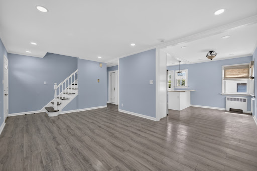 Living room with stairs and open kitchen - Rent this luxury house in Williston Park, 4 bedrooms