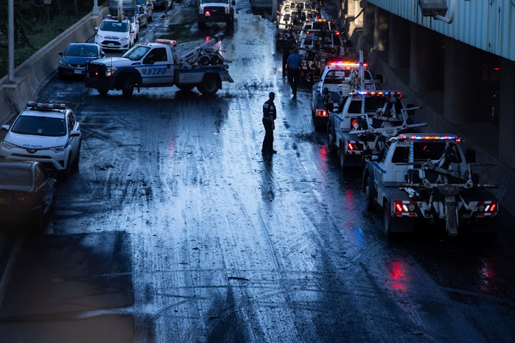 A member of the NYPD supervises tow trucks clearing cars abandoned on the Major Deegan Expressway after the remnants of Tropical Storm Ida brought drenching rain, flash floods and tornadoes to parts of the northern mid-Atlantic, in the Bronx borough of New York City, US, September 2, 2021.