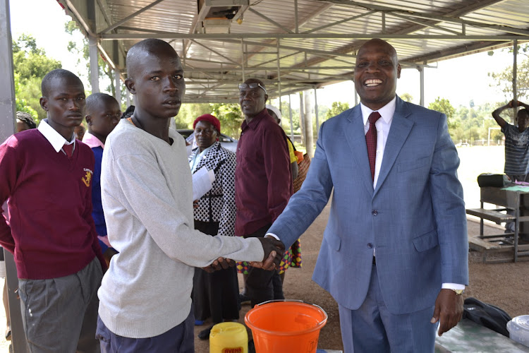 Yusuf Aker being received by Kapsabet principal Kipchumba Maiyo on Friday afternoon.