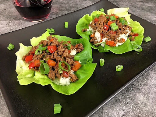 Two delicious Korean Beef Lettuce Wraps topped with green onions.