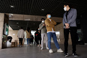 People line up to take nucleic acid tests at a makeshift testing site in an office complex following the Covid-19 outbreak in Beijing, China on April 26, 2022. 