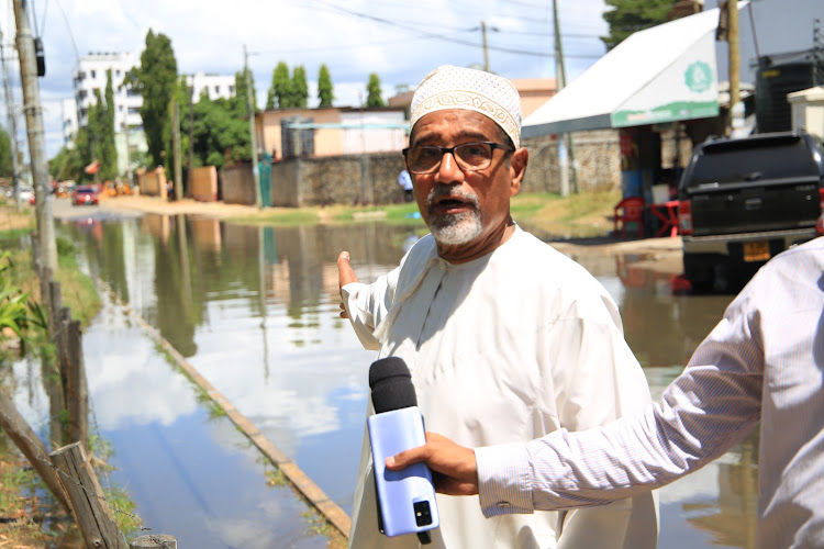 Muhuri director Khelef Khalifa pointing to raw sewage spilling into a road in Tudor Four area on Wednesday.