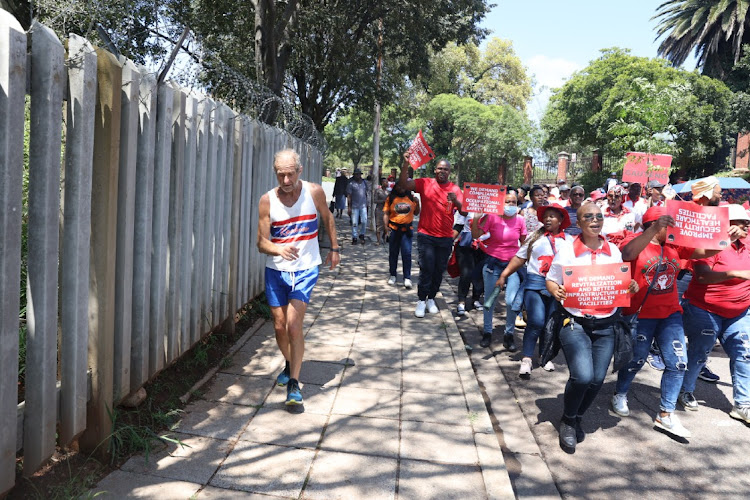 Members of the National Education, Health and Allied Workers' Union (Nehawu) marching along the street outside Charlotte Maxeke Hospital. Protesters closed down the entrances to the hospital with rocks during their strike for a 10% wage increase.