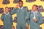 Bryan Katoo, left, Sihle Mahlangu and Bayanda Walaza pose with their U-20 world championship medals at OR Tambo Airport. 