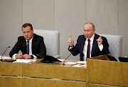 Russian President Vladimir Putin (R) and Dmitry Medvedev.