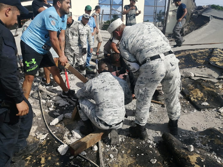 Members of security forces and people work at a site where a church roof collapsed during Sunday mass in Ciudad Madero, in Mexico in this handout picture distributed to Reuters on October 1 2023.