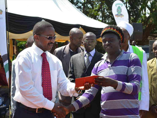 Governor Mwangi wa Iria issuing a license to a boda boda operator at Kahuro shopping centre on Friday.