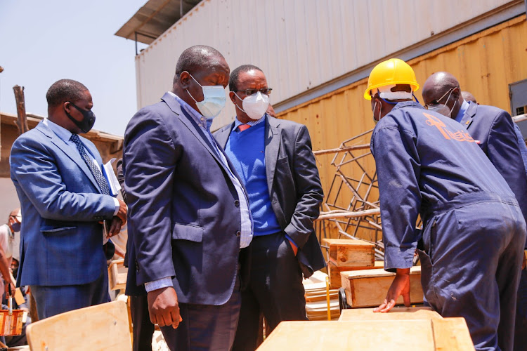 Interior CS Fred Matiangi,and Karanja Kibicho during a visit at Dean Achesa's workshop in Umoja, Nairobi to examine progress of students' furniture production.