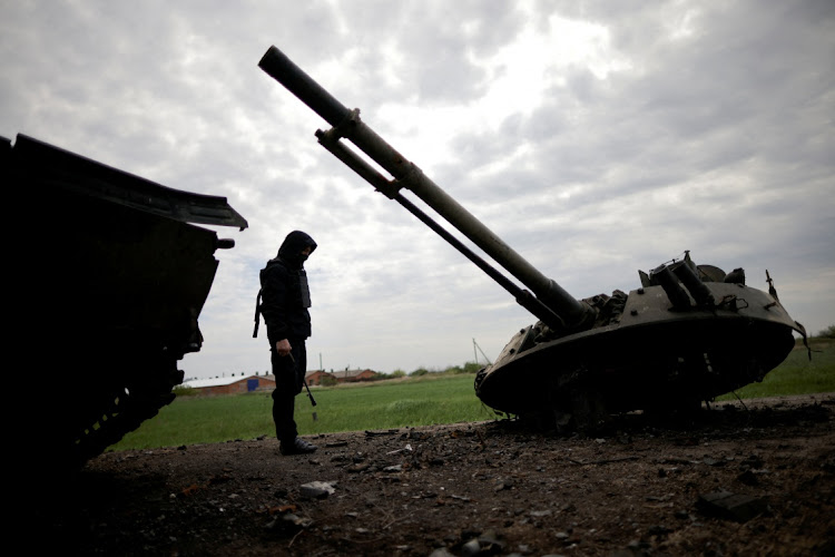 A Ukrainian service member inspects a destroyed Russian Armoured Personnel Carrier (APC), amid Russia's invasion of Ukraine, in the Zaporizhzhia region on April 30 2022.