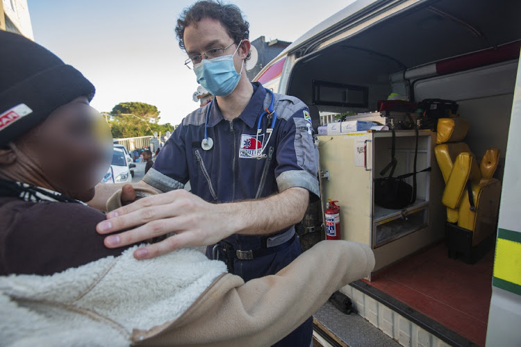 Paramedic Mathew Rosenberg prepares an injured resident for treatment outside the volunteer ambulance in Imizamo Yethu, Hout Bay.