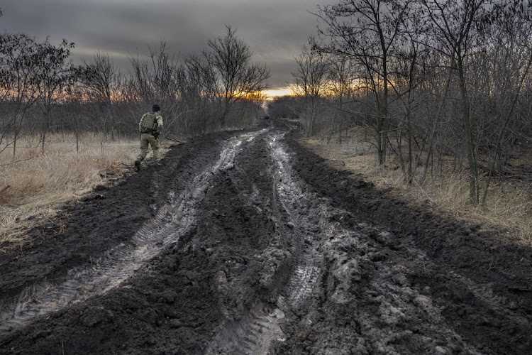 A soldier from a Ukrainian assault brigade walks along a muddy road used to transport and position British made L118 105mm Howitzers on March 04, 2023 near Bakhmut, Ukraine. Soldiers said they received training on the towed light guns in Germany last summer but took possession of the artillery pieces, sent by the UK, in January, 2023.