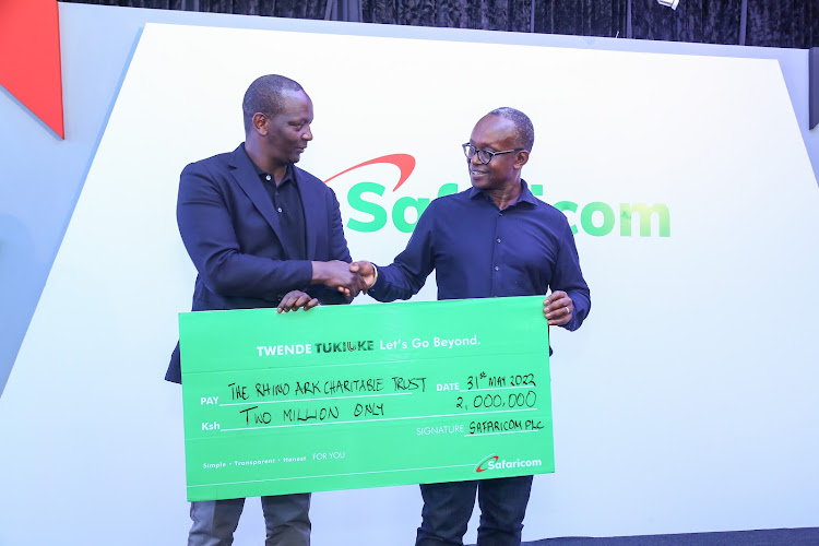 M-pesa Africa managing director, Sitoyo Lopokoiyit (L), presents a dummy cheque of Sh2m to Kenya Forest Service chairman, Peter Kinyua.