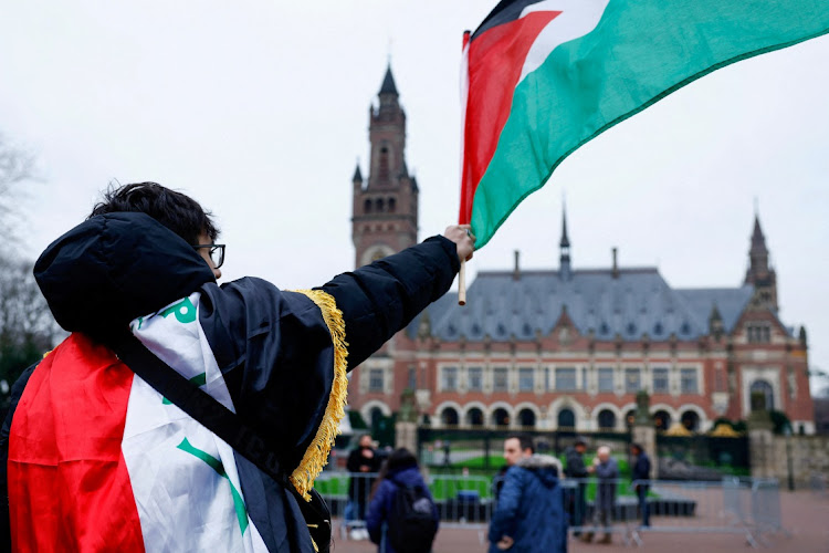 A man waves a Palestinian flag outside the International Court of Justice in the Hague, the Netherlands, February 21 2024. Picture: REUTERS/Piroschka van de Wouw