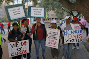 Protesters hold placards demanding the Gauteng health department do more in its fight against cancer.